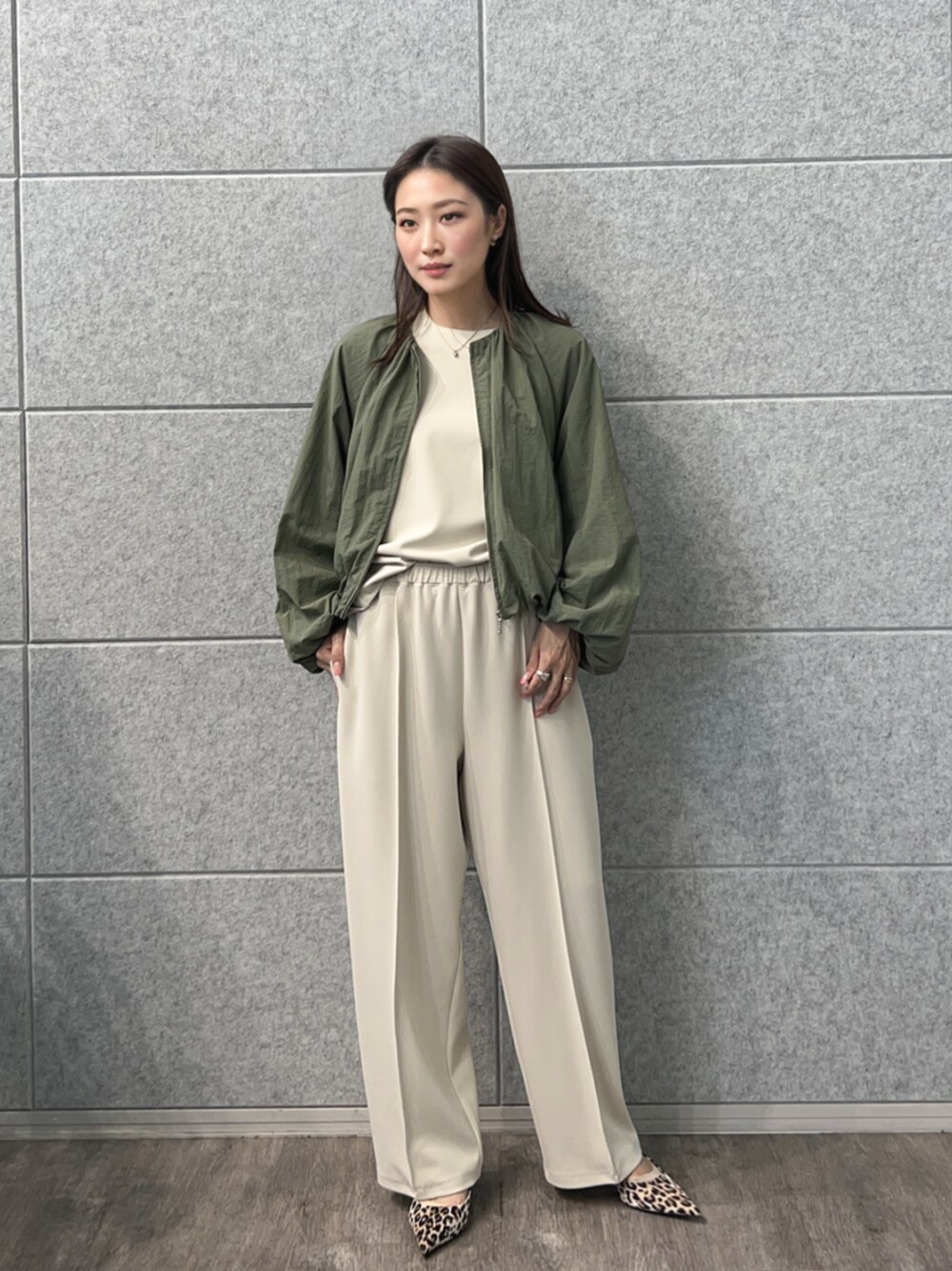 グリーン系のブルゾン、ベージュ系のその他パンツ、ベージュ系のTシャツ/カットソーを着用したレディースの秋コーディネートの1枚目の写真