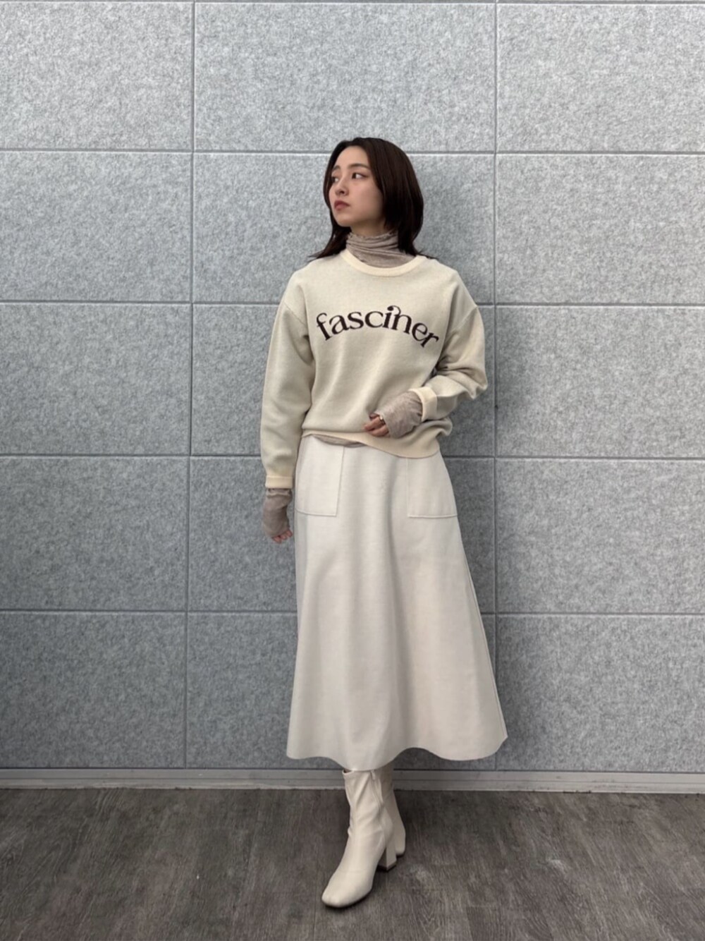 ホワイト系のスカート、ホワイト系のニット/セーター、ベージュ系のTシャツ/カットソーを着用したレディースの秋コーディネートの1枚目の写真