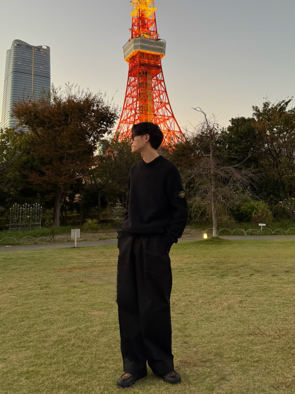 ブラック系のチノパンツ、ブラック系のスニーカー、ブラック系のニット/セーターを着用したメンズの秋コーディネートの1枚目の写真