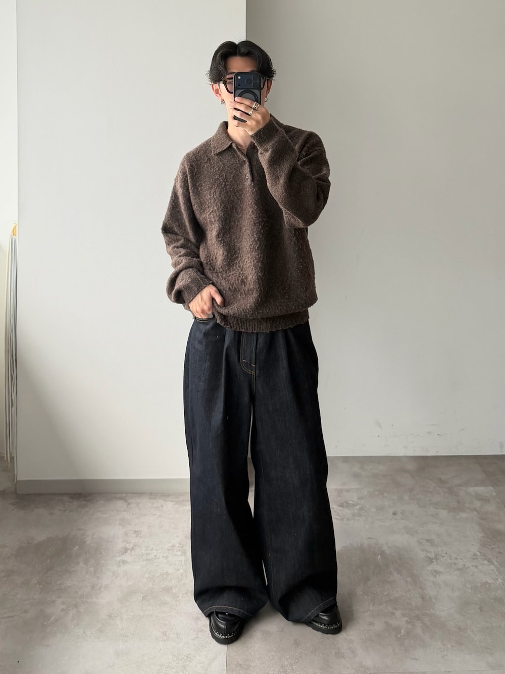 ブラウン系のニット/セーター、ブルー系のデニムパンツ、ブラック系のドレスシューズを着用したメンズの冬コーディネートの1枚目の写真