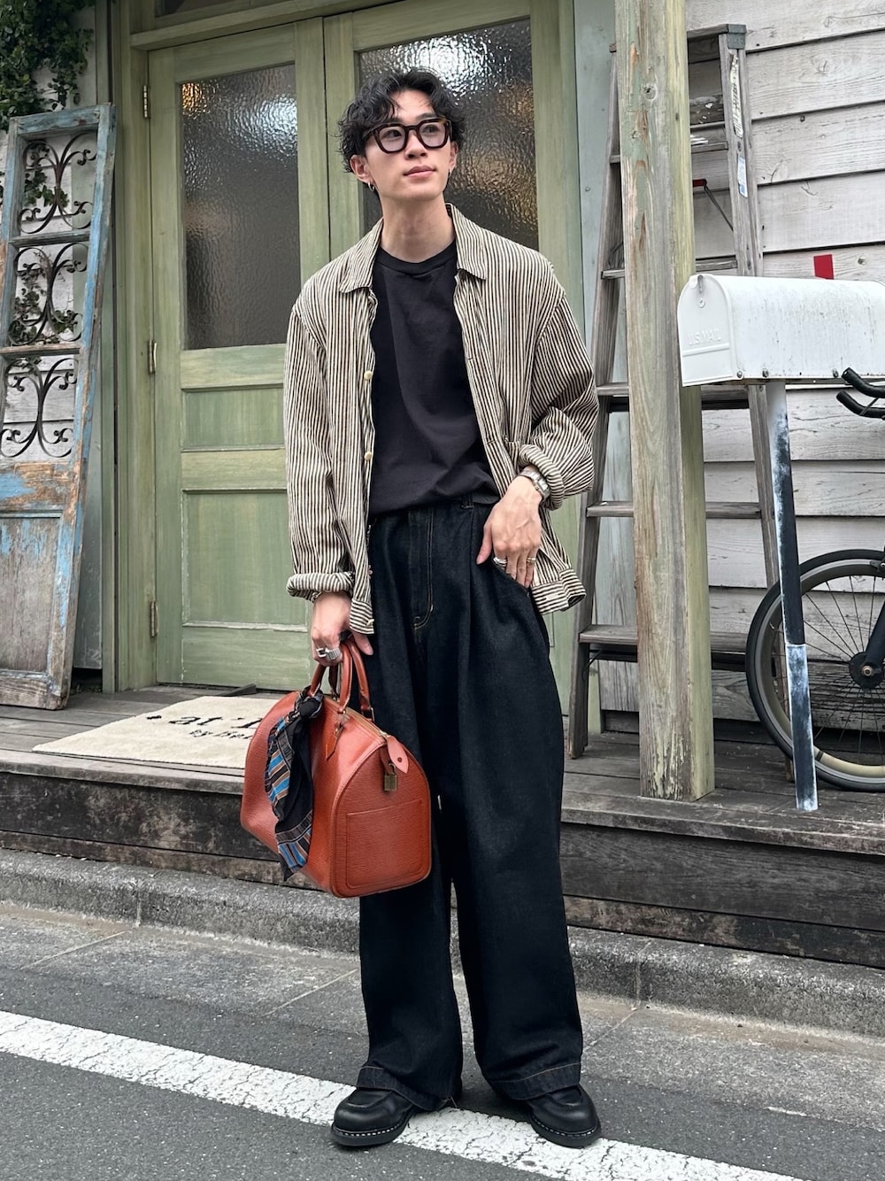 ブラック系のTシャツ/カットソー、ベージュ系のブルゾン、ブラック系のデニムパンツを着用したメンズの春コーディネートの1枚目の写真