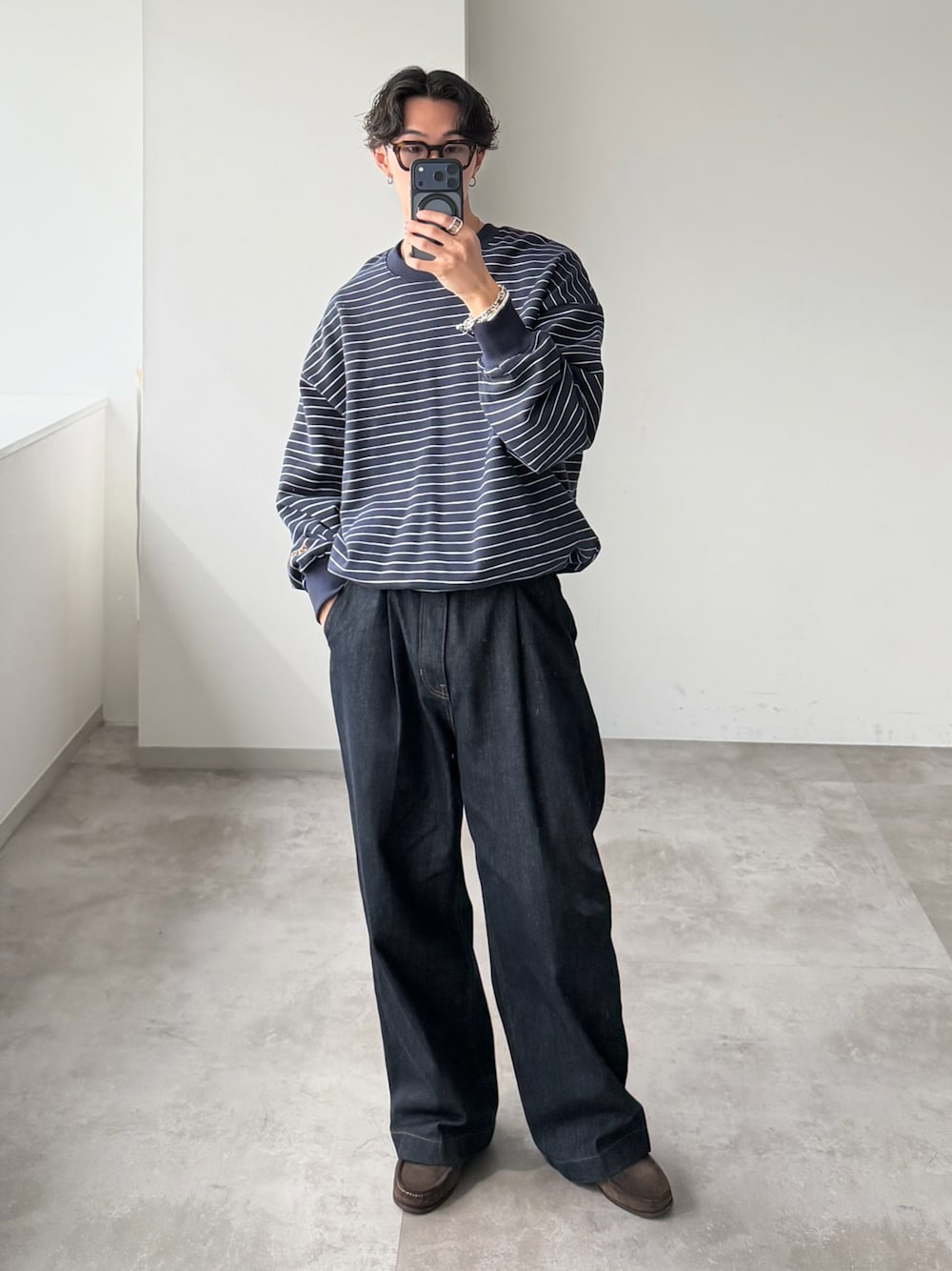 ブルー系のスウェット、ブルー系のデニムパンツ、ブラウン系のローファーを着用したメンズの秋コーディネートの1枚目の写真