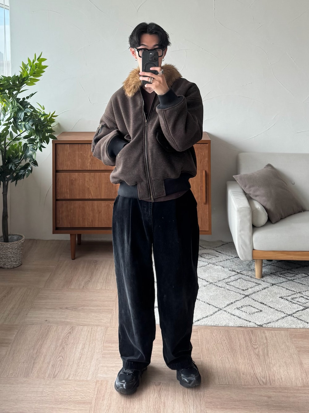 ブラウン系のブルゾン、ブラック系のスラックス、ブラック系のスニーカーを着用したメンズの秋コーディネートの1枚目の写真