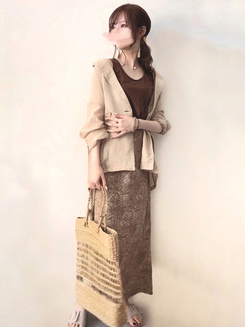 ベージュ系のテーラードジャケット、ベージュ系のスカート、ベージュ系のかごバッグを着用したレディースの夏コーディネートの1枚目の写真
