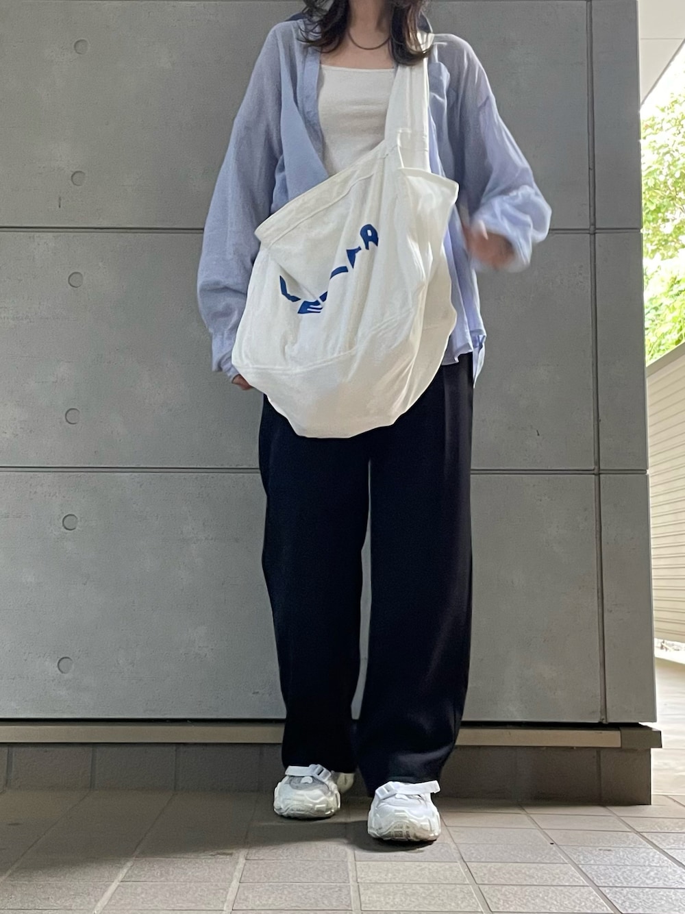 ブラック系のチノパンツを着用したレディースの秋コーディネートの1枚目の写真