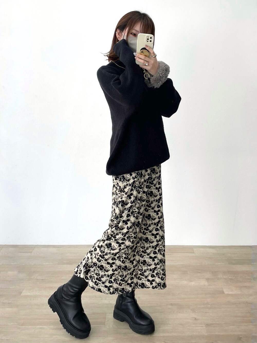 ブラック系のニット/セーター、ブラック系のブーツを着用したレディースの春コーディネートの1枚目の写真