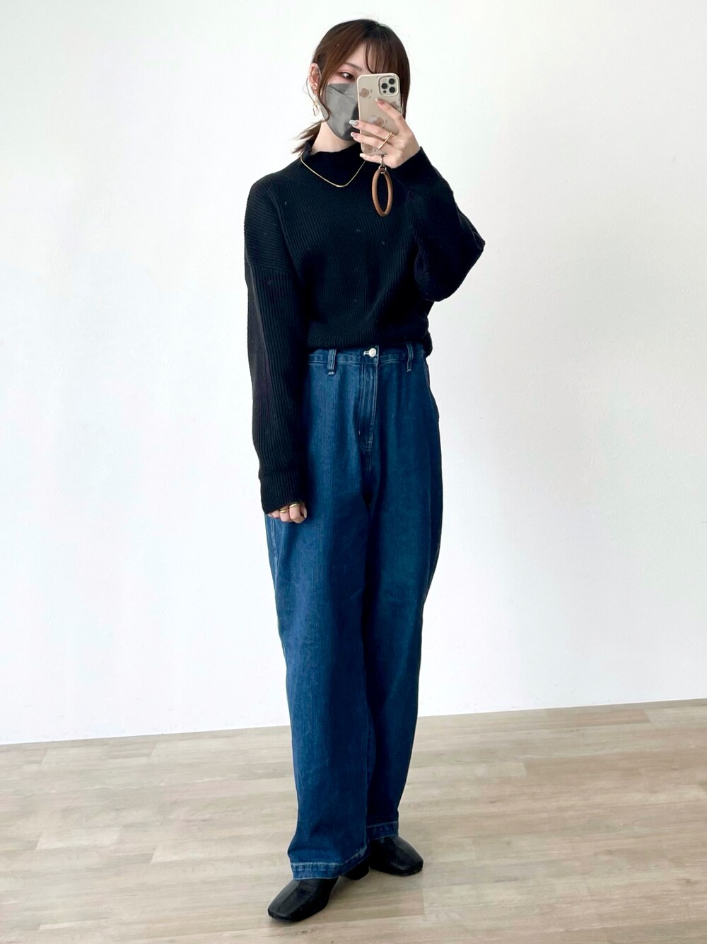 ブルー系のデニムパンツ、ブラック系のニット/セーターを着用したレディースの冬コーディネートの1枚目の写真