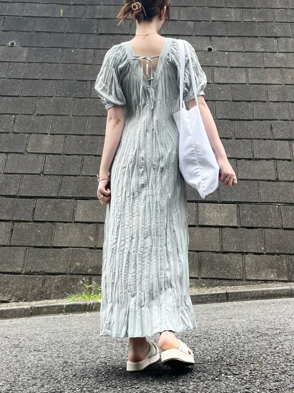 ホワイト系のサンダルを着用したレディースの夏コーディネートの1枚目の写真