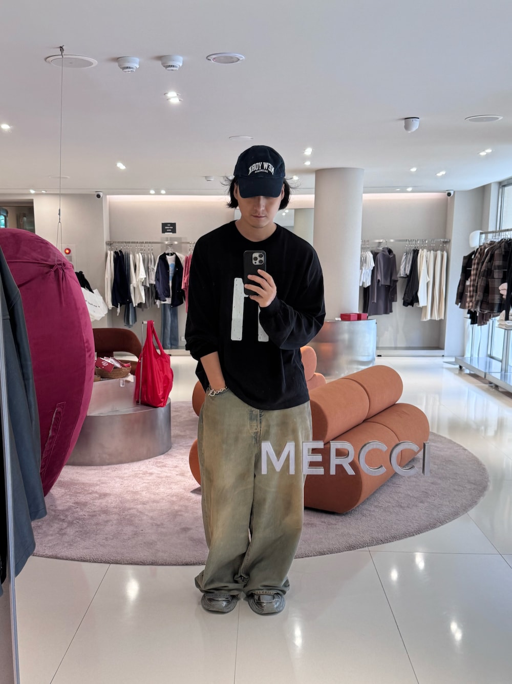 ブラック系のトップス、ブルー系のパンツ、グレー系のシューズを着用したメンズの秋コーディネートの1枚目の写真