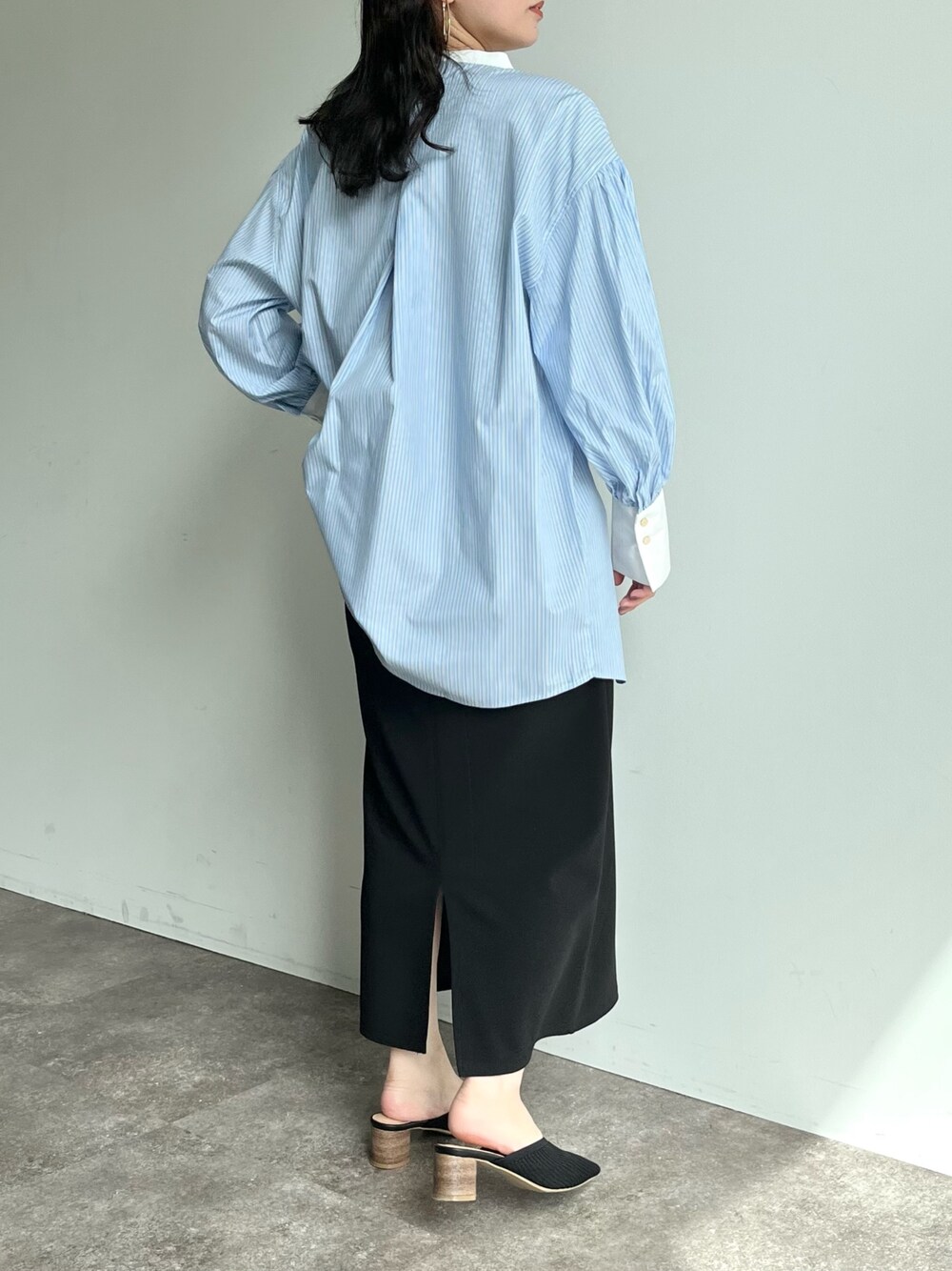 ブラック系のスカート、ブルー系のシャツ/ブラウス、ブラック系のパンプスを着用したレディースの春コーディネートの3枚目の写真