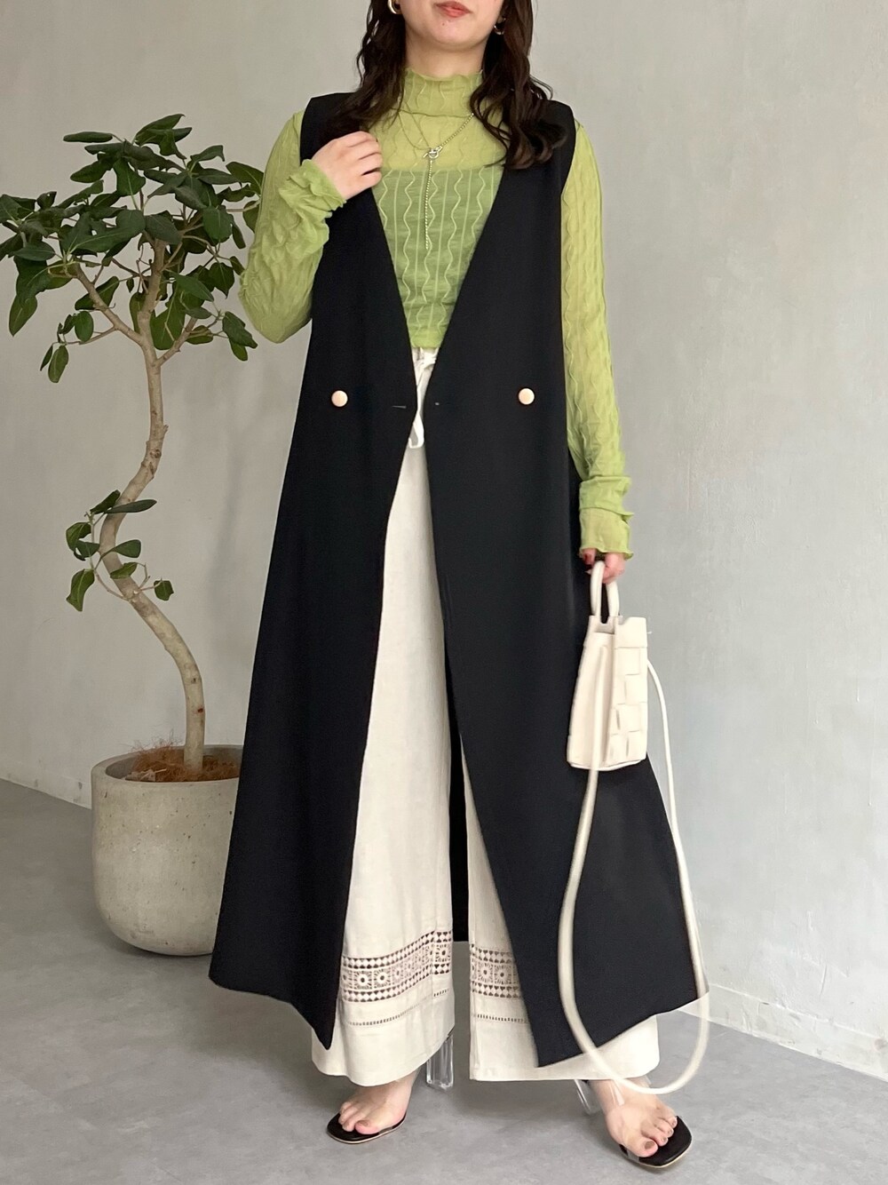 ベージュ系のその他パンツ、ブラック系のジャンパースカート、ホワイト系のショルダーバッグを着用したレディースの春コーディネートの2枚目の写真