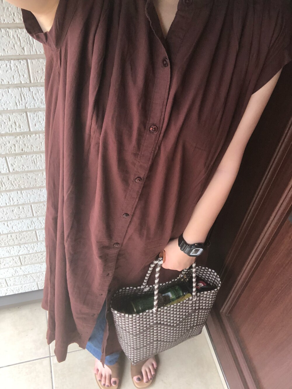 ブラウン系のワンピース、ブルー系のデニムパンツ、ブラウン系のトートバッグを着用したレディースの夏コーディネートの1枚目の写真