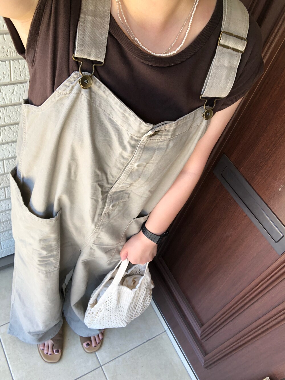 ブラウン系のTシャツ/カットソー、ベージュ系のサロペット/オーバーオール、ブラウン系のサンダルを着用したレディースの夏コーディネートの1枚目の写真