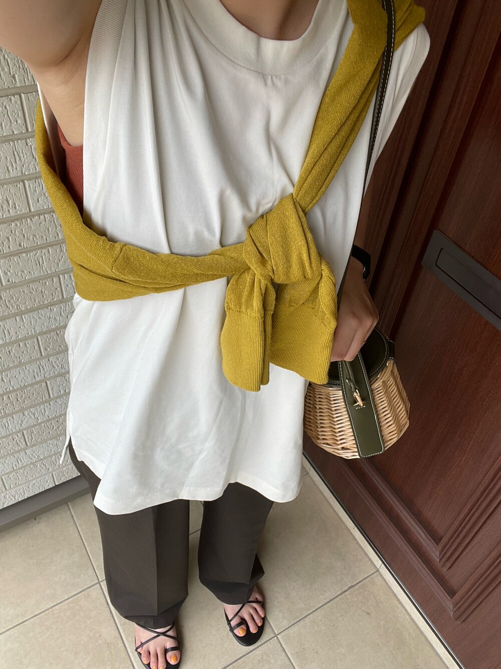 グリーン系のかごバッグを着用したレディースの夏コーディネートの1枚目の写真