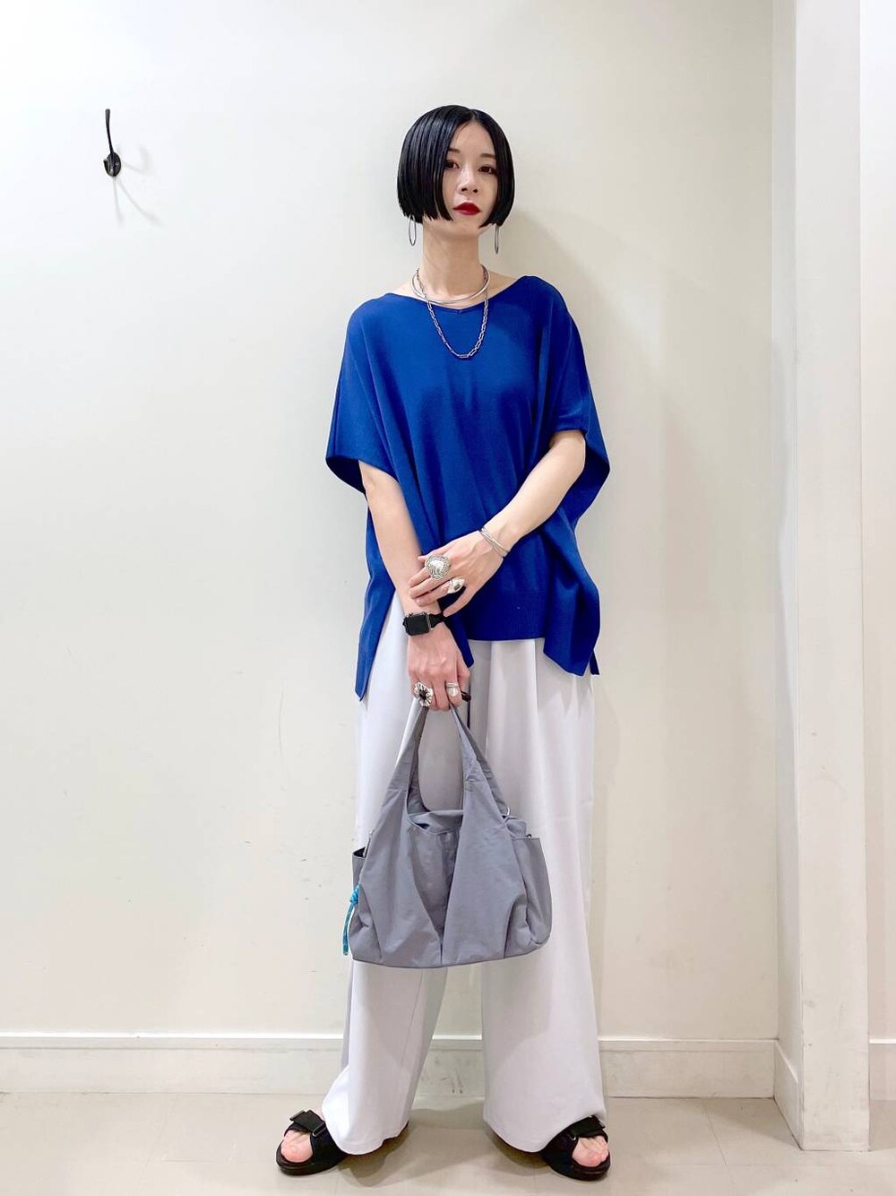 グレー系のその他パンツ、ブルー系のニット/セーター、グレー系のトートバッグを着用したレディースの夏コーディネートの1枚目の写真