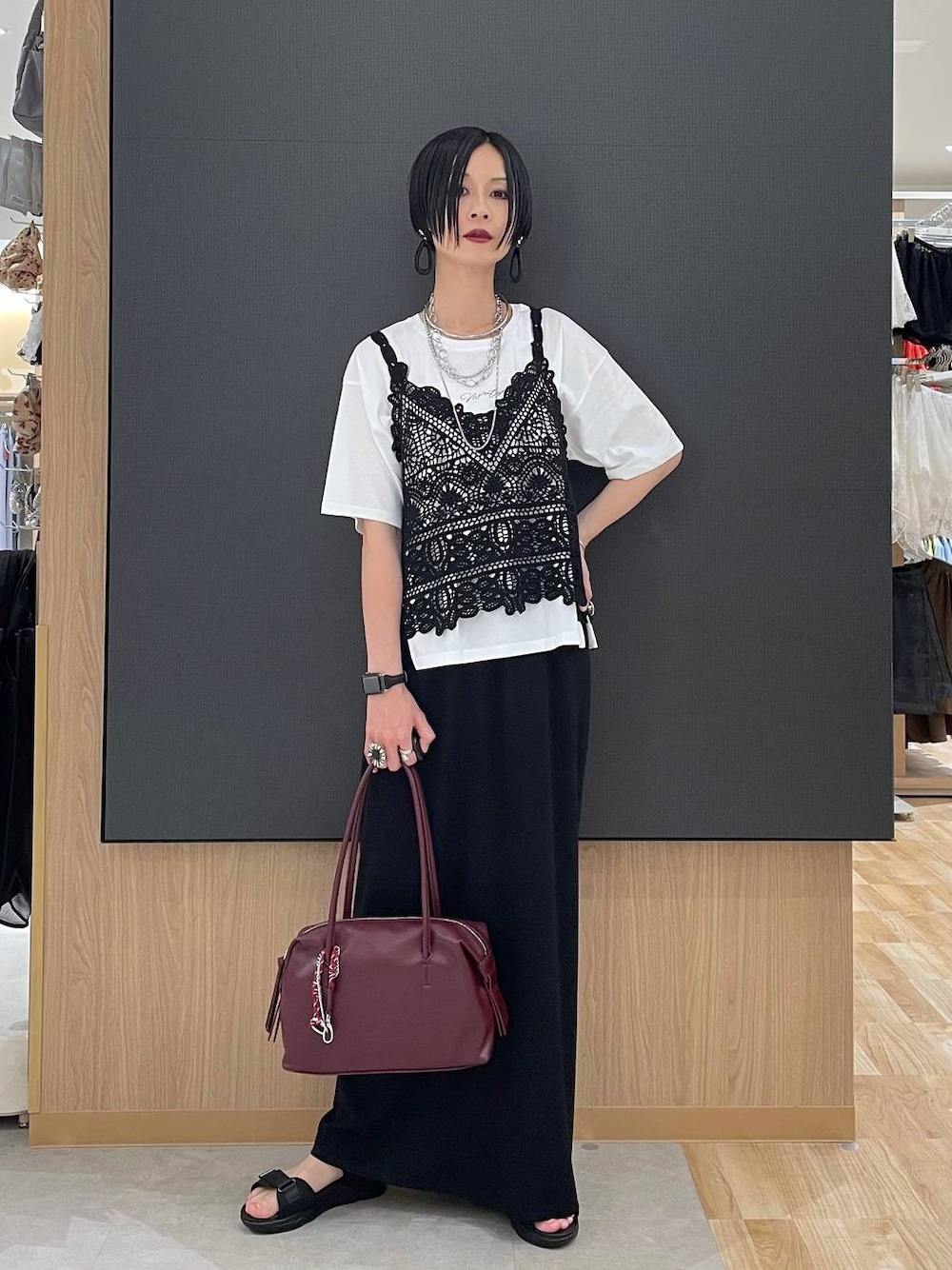 ブラック系のスカート、レッド系のボストンバッグ、ホワイト系のTシャツ/カットソーを着用したレディースの夏コーディネートの1枚目の写真