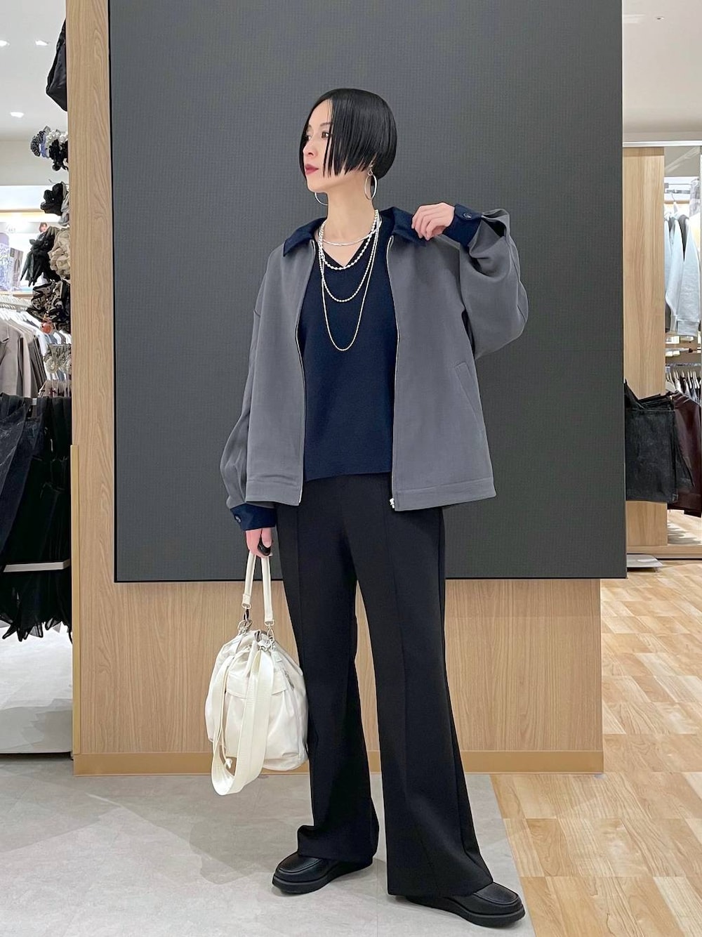 ブラック系のローファー、ホワイト系のショルダーバッグ、ブラック系のスウェットパンツを着用したレディースの春コーディネートの1枚目の写真