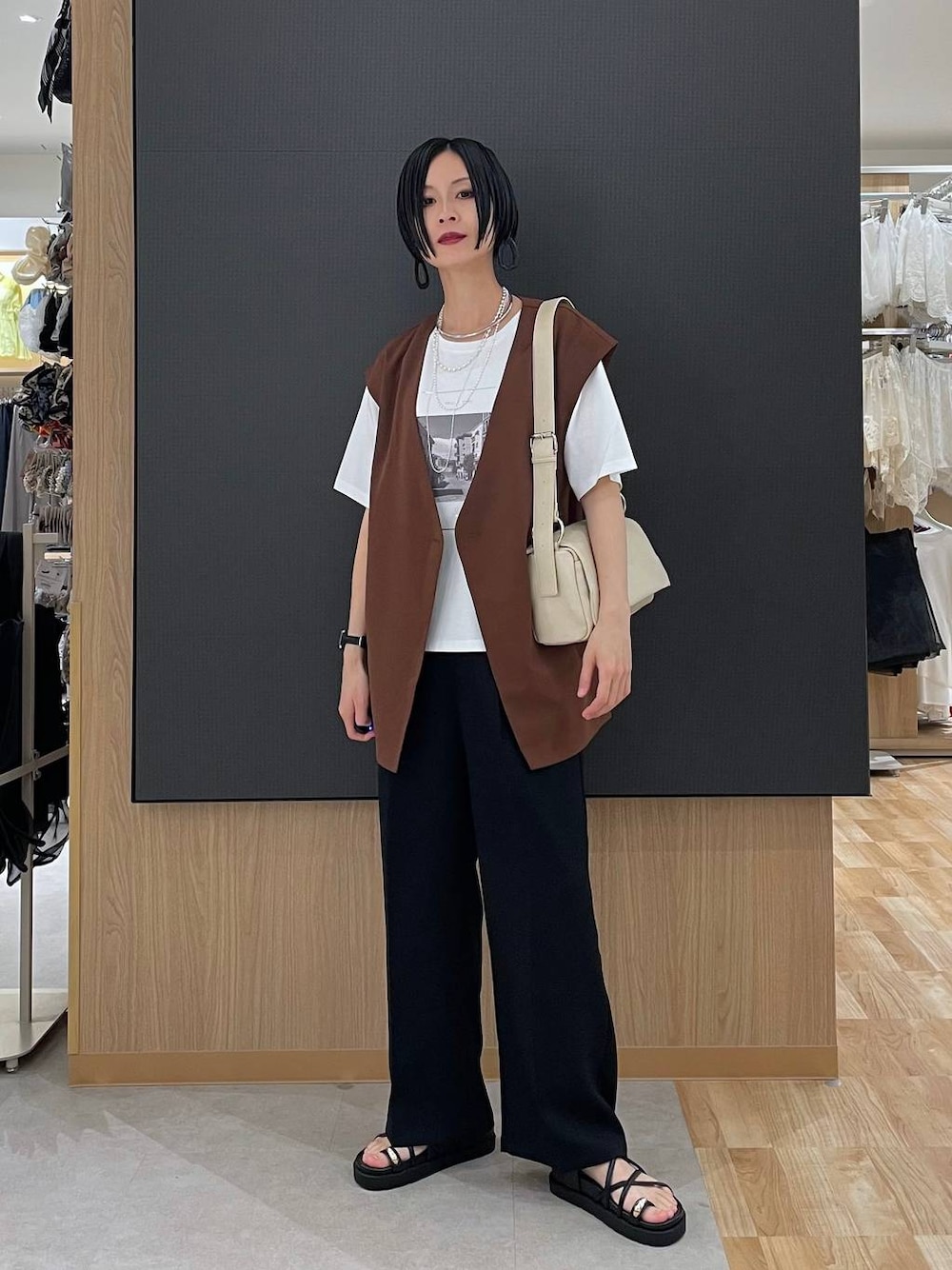 ブラック系のその他パンツ、ホワイト系のTシャツ/カットソー、ブラック系のサンダルを着用したレディースの春コーディネートの1枚目の写真