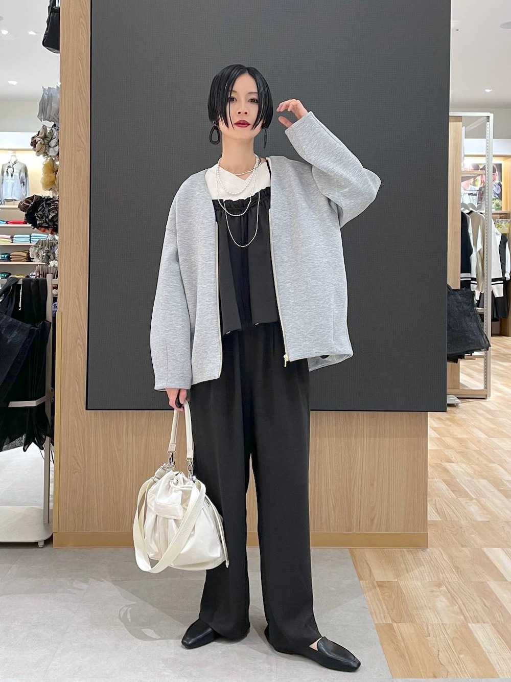 ブラック系のその他シューズ、ホワイト系のショルダーバッグ、グレー系のブルゾンを着用したレディースの春コーディネートの1枚目の写真