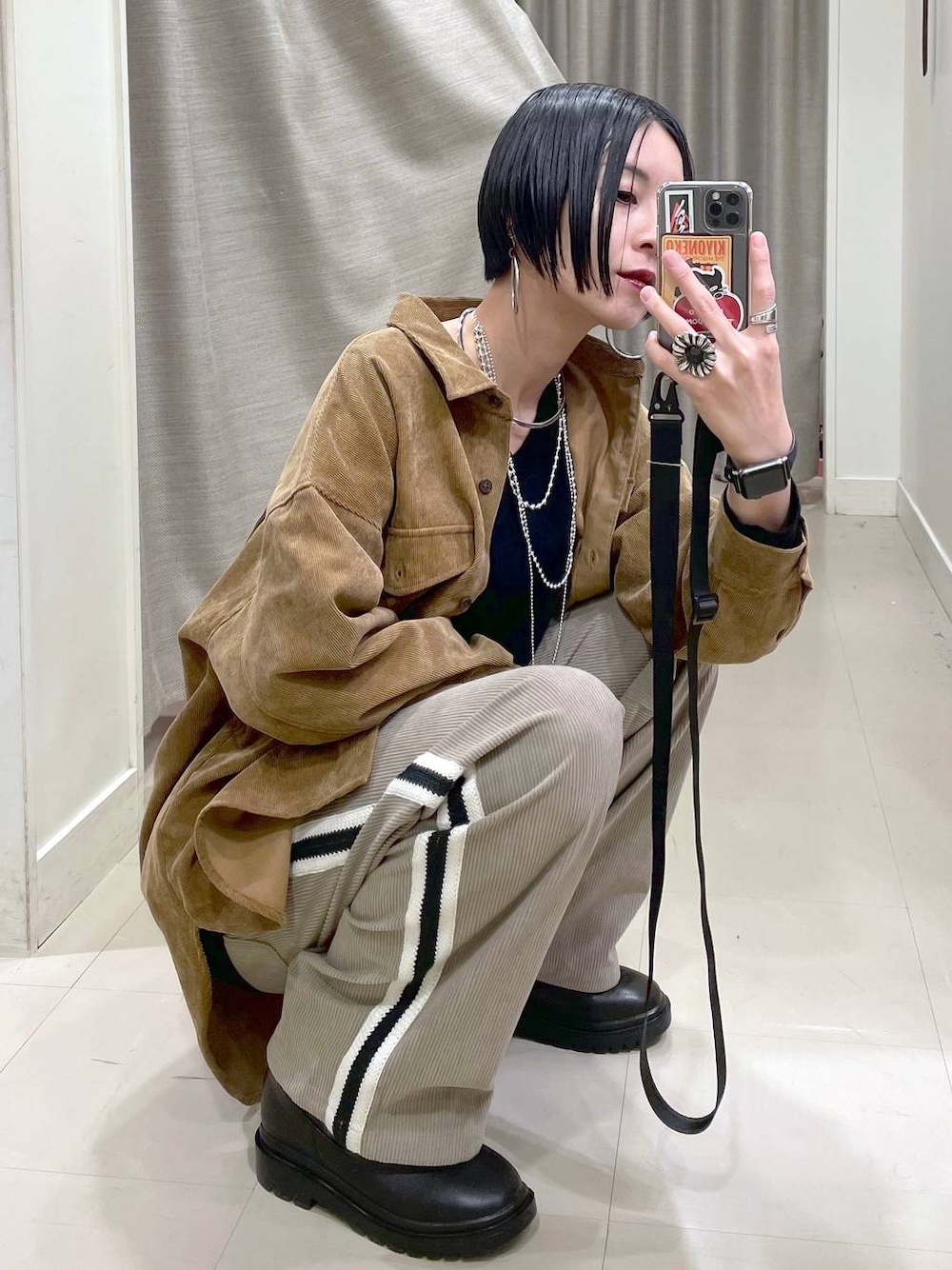 イエロー系のシャツ/ブラウス、ブラック系のスウェット、ブラック系のブーツを着用したレディースの秋コーディネートの1枚目の写真