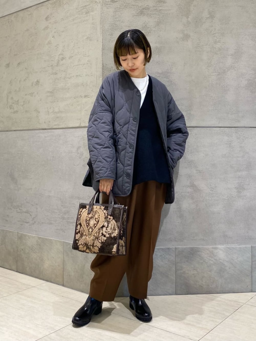 ブラウン系のその他パンツ、ブラック系のブーツ、ホワイト系のTシャツ/カットソーを着用したレディースの秋コーディネートの1枚目の写真