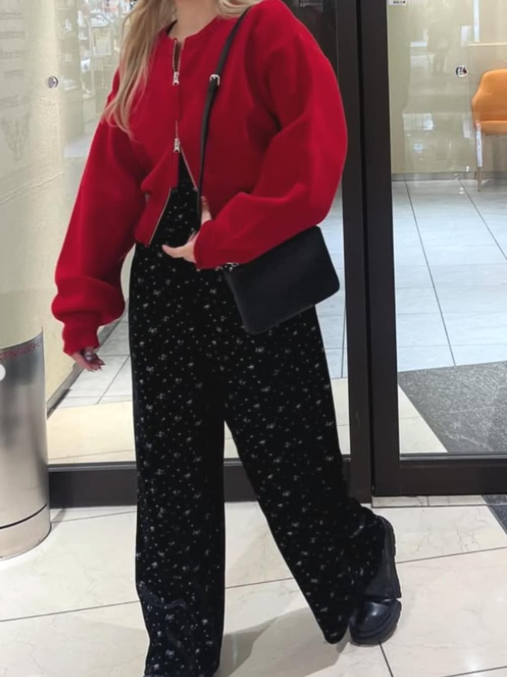 ピンク系のスウェットパンツ、レッド系のカーディガン/ボレロ、ブラック系のショルダーバッグを着用したレディースの秋コーディネートの1枚目の写真