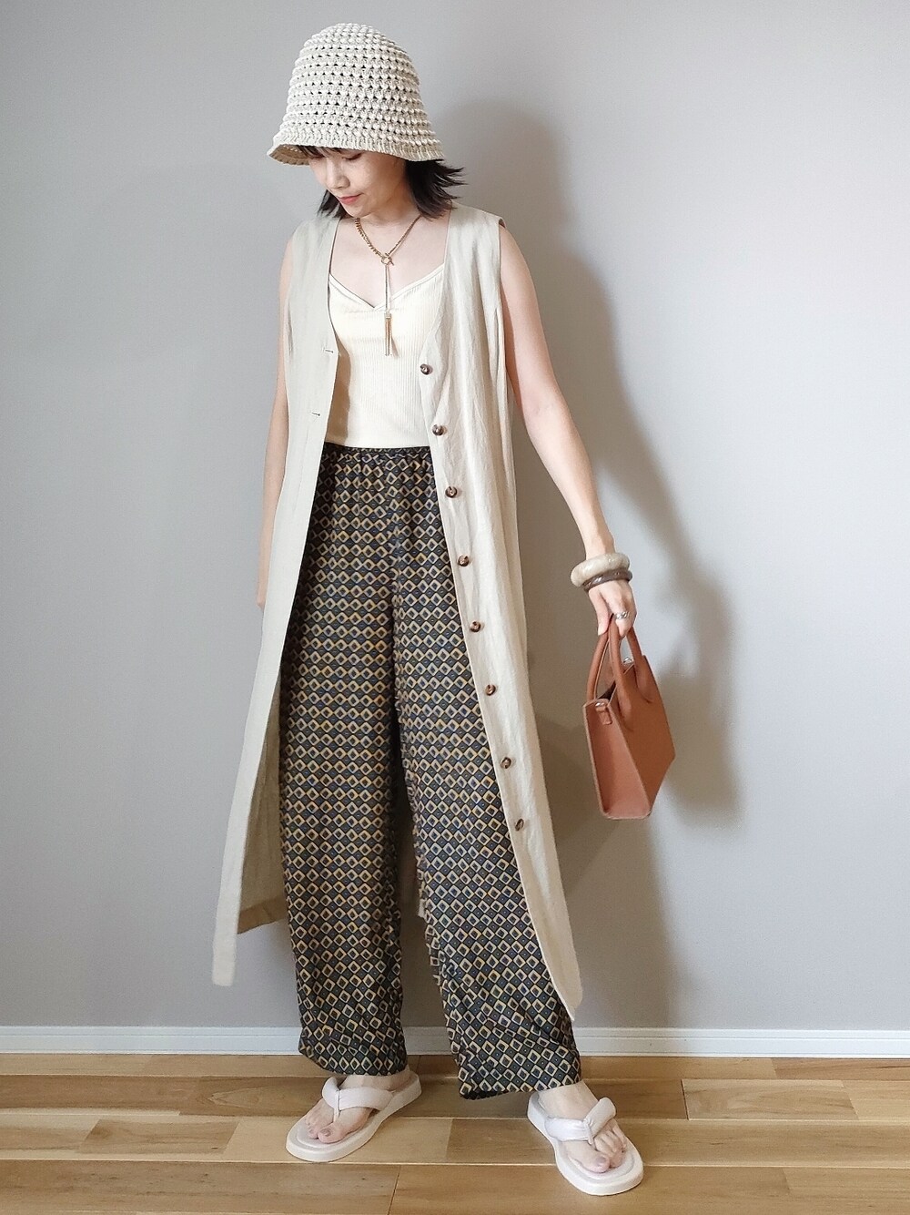 ホワイト系のキャミソール、ブルー系のその他パンツ、ブラウン系のショルダーバッグを着用したレディースの夏コーディネートの1枚目の写真