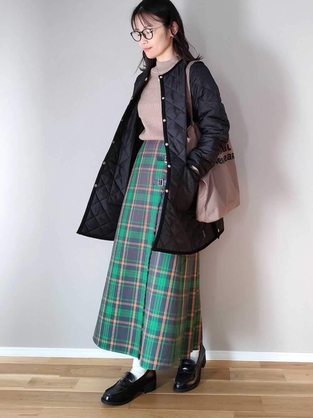 ブラック系のその他アウター、ブラウン系のトートバッグ、ベージュ系のニット/セーターを着用したレディースの冬コーディネートの1枚目の写真