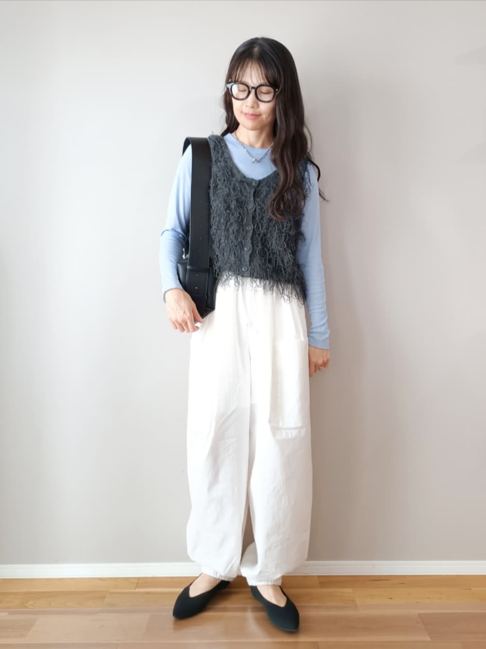 グレー系のベスト、ピンク系のTシャツ/カットソー、ホワイト系のカーゴパンツを着用したレディースの春コーディネートの1枚目の写真