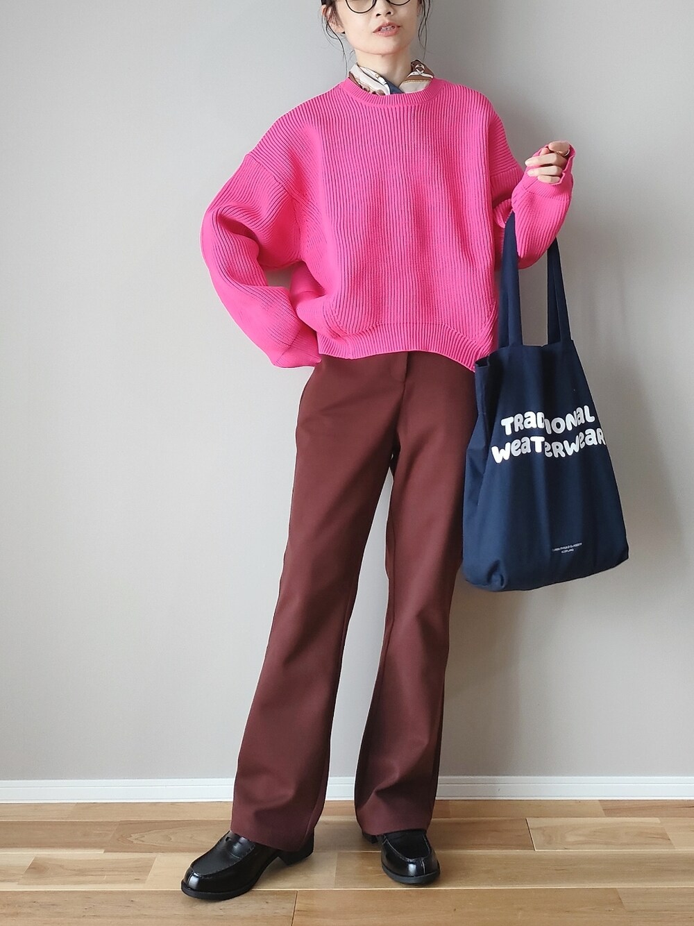 ピンク系のニット/セーター、ブラウン系のスラックス、ブルー系のトートバッグを着用したレディースの秋コーディネートの1枚目の写真