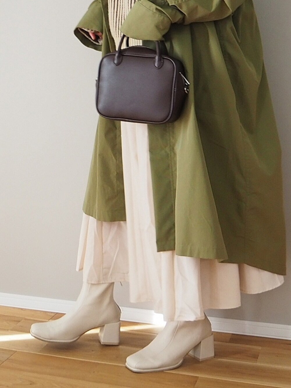 ブラウン系のニット/セーター、ベージュ系のシャツワンピース、グリーン系のモッズコートを着用したレディースの冬コーディネートの3枚目の写真