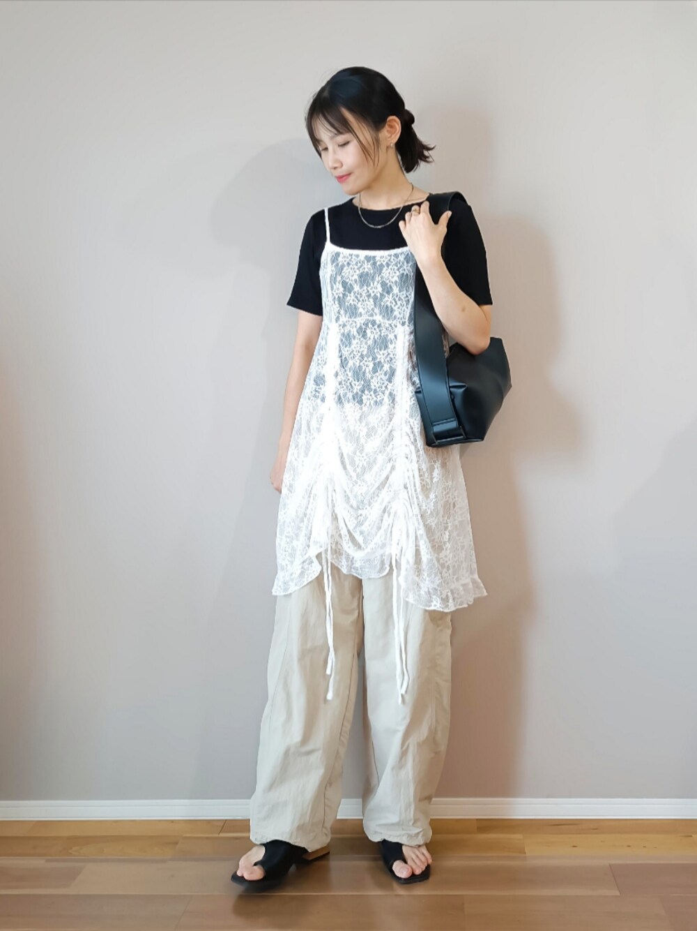 ホワイト系のチュニック、ホワイト系のパンツ、ブラック系のTシャツ/カットソーを着用したレディースの春コーディネートの1枚目の写真
