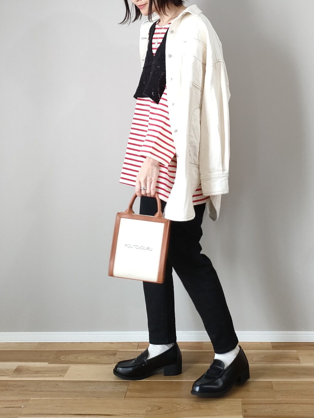 レッド系のTシャツ/カットソー、ブラック系のデニムパンツ、ブラック系のローファーを着用したレディースの春コーディネートの4枚目の写真