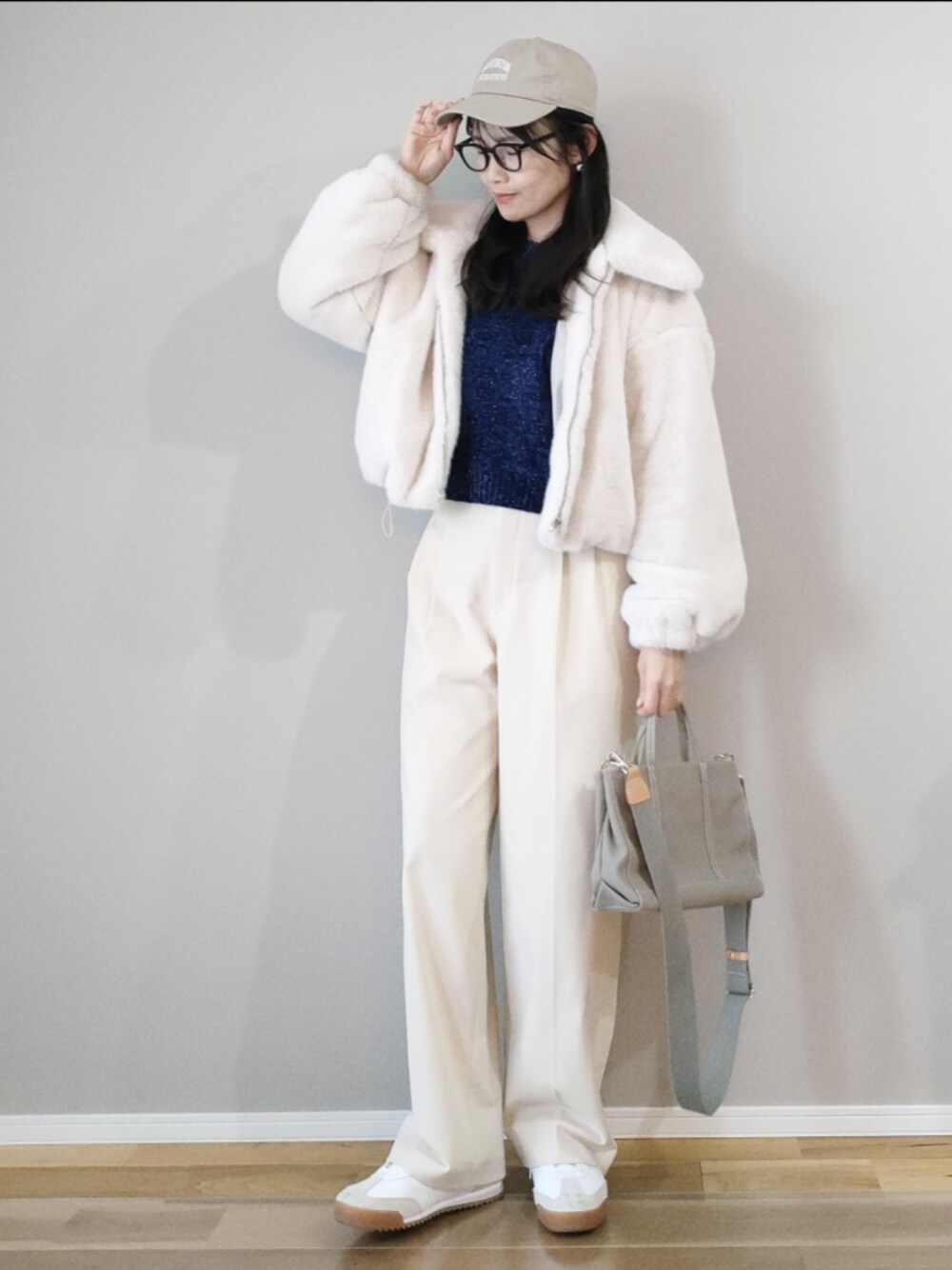ブルー系のニット/セーター、ホワイト系のブルゾン、ホワイト系のパンツを着用したレディースの冬コーディネートの1枚目の写真
