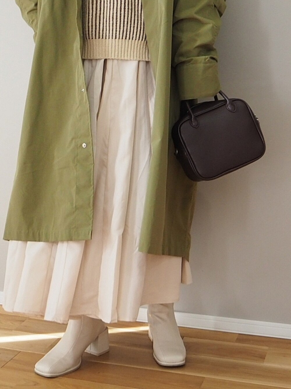 ブラウン系のニット/セーター、ベージュ系のシャツワンピース、グリーン系のモッズコートを着用したレディースの冬コーディネートの2枚目の写真