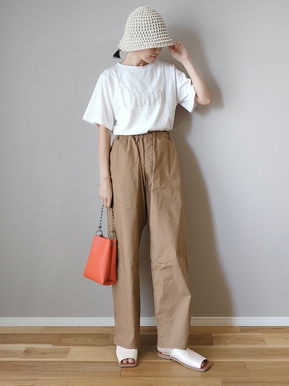 ホワイト系のTシャツ/カットソー、オレンジ系のショルダーバッグ、ベージュ系のその他パンツを着用したレディースの夏コーディネートの1枚目の写真