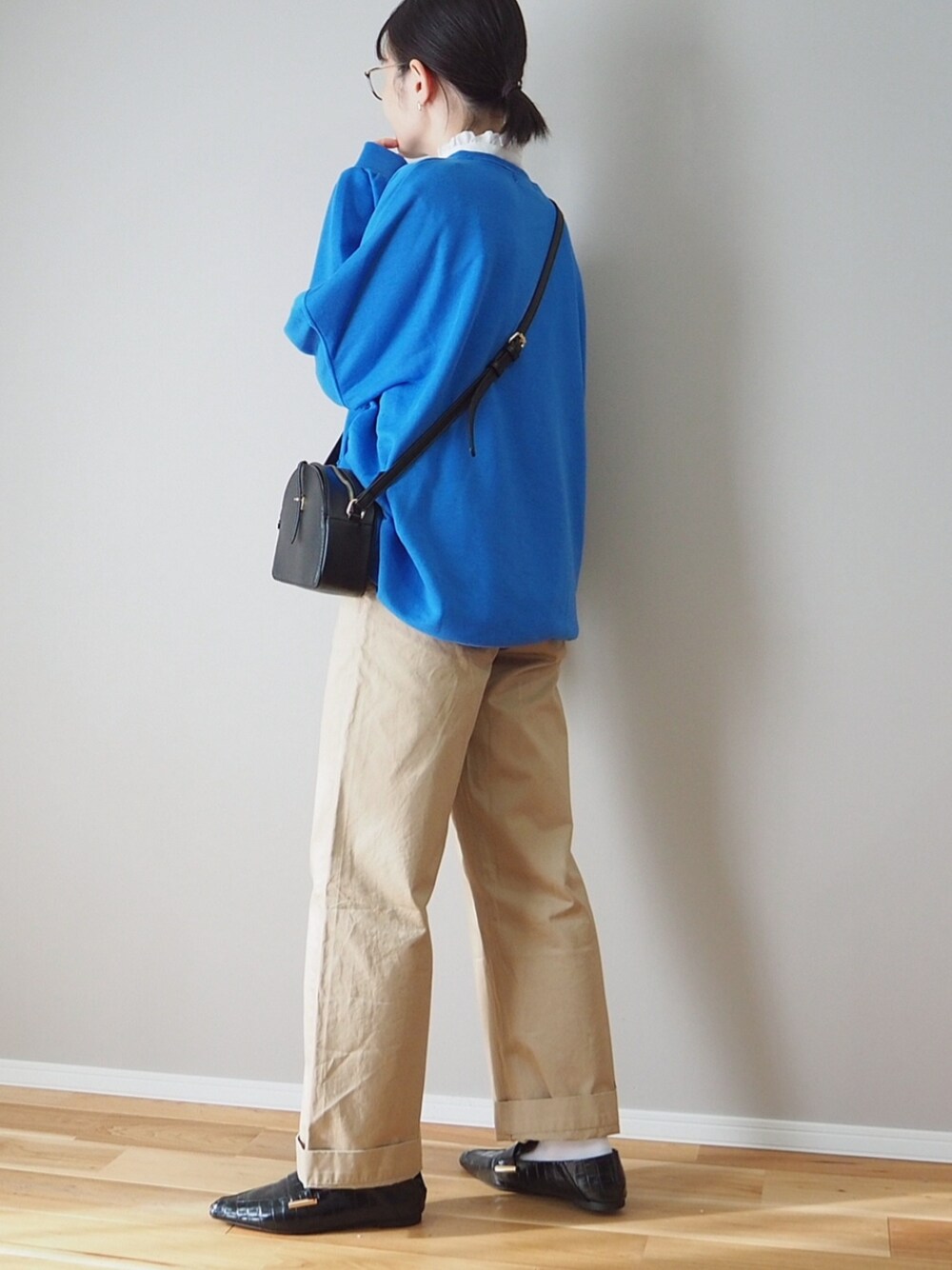 ブルー系のスウェット、ブラック系のショルダーバッグ、その他のドレスシューズを着用したレディースの冬コーディネートの3枚目の写真