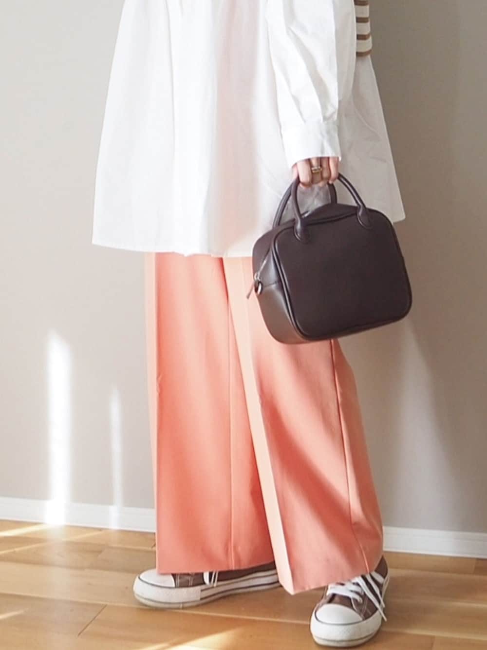 ホワイト系のシャツ/ブラウス、ブラウン系のボストンバッグ、ピンク系のスラックスを着用したレディースの冬コーディネートの2枚目の写真