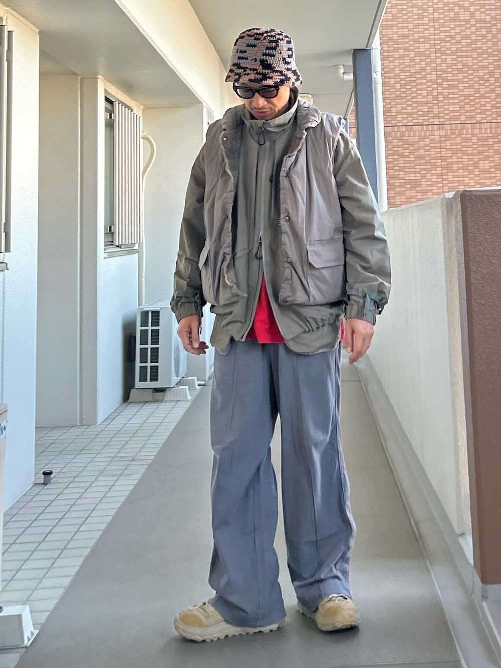 グレー系のマウンテンパーカー、グレー系のベスト、グレー系のその他パンツを着用したメンズの冬コーディネートの1枚目の写真