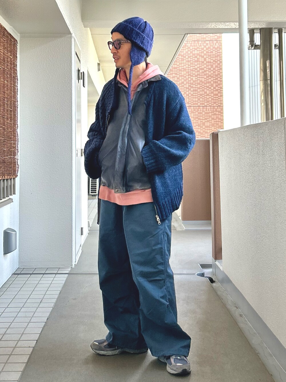 「真冬のあったかスタイル、冬コーデ、レイヤードスタイル、カーディガン、レザージャケット、ワイドパンツ、サングラス、大人カジュアル、ブルー、ニューバランス」｜「UNE MANSIONのフライトキャップ/ニット耳あて帽子（ニットキャップ/ビーニー、ブルー系）」を使った、yosukeさん（メンズ・168cm）の冬コーディネートの1枚目の写真