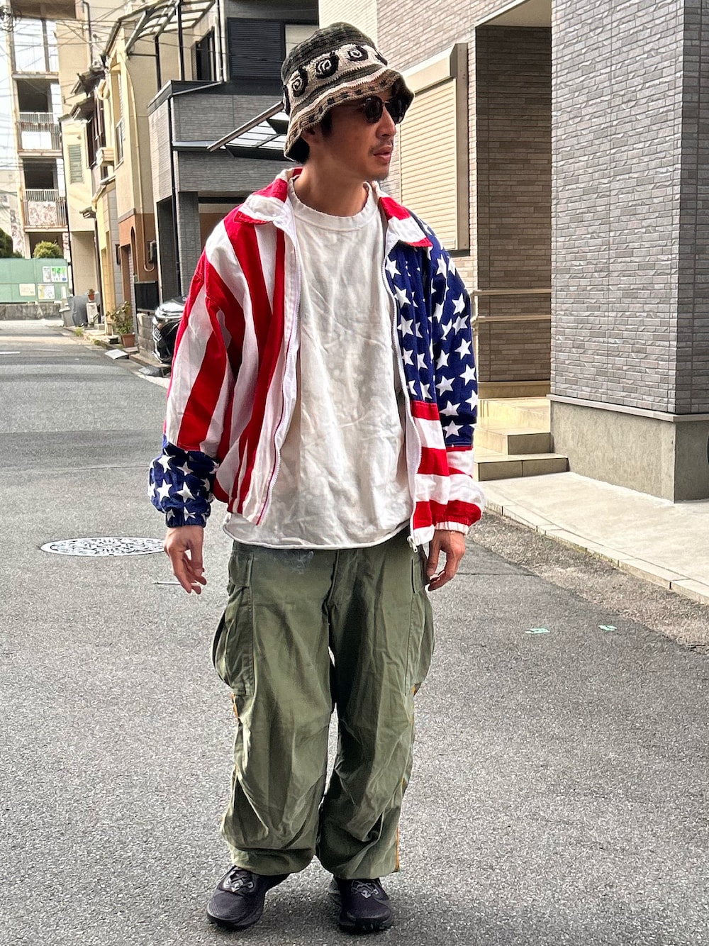 「春のNewスタイル、春服コーデ、古着コーデ、アメカジコーデ、星条旗、ゆるコーデ、春コーデ、カーゴパンツ、バケットハット」｜「VINTAGEの【ヴィンテージ古着】90's Carabella "Budweiser" コットンジャケット（ブルゾン、レッド系）」を使った、yosukeさん（メンズ・168cm）の春コーディネートの1枚目の写真