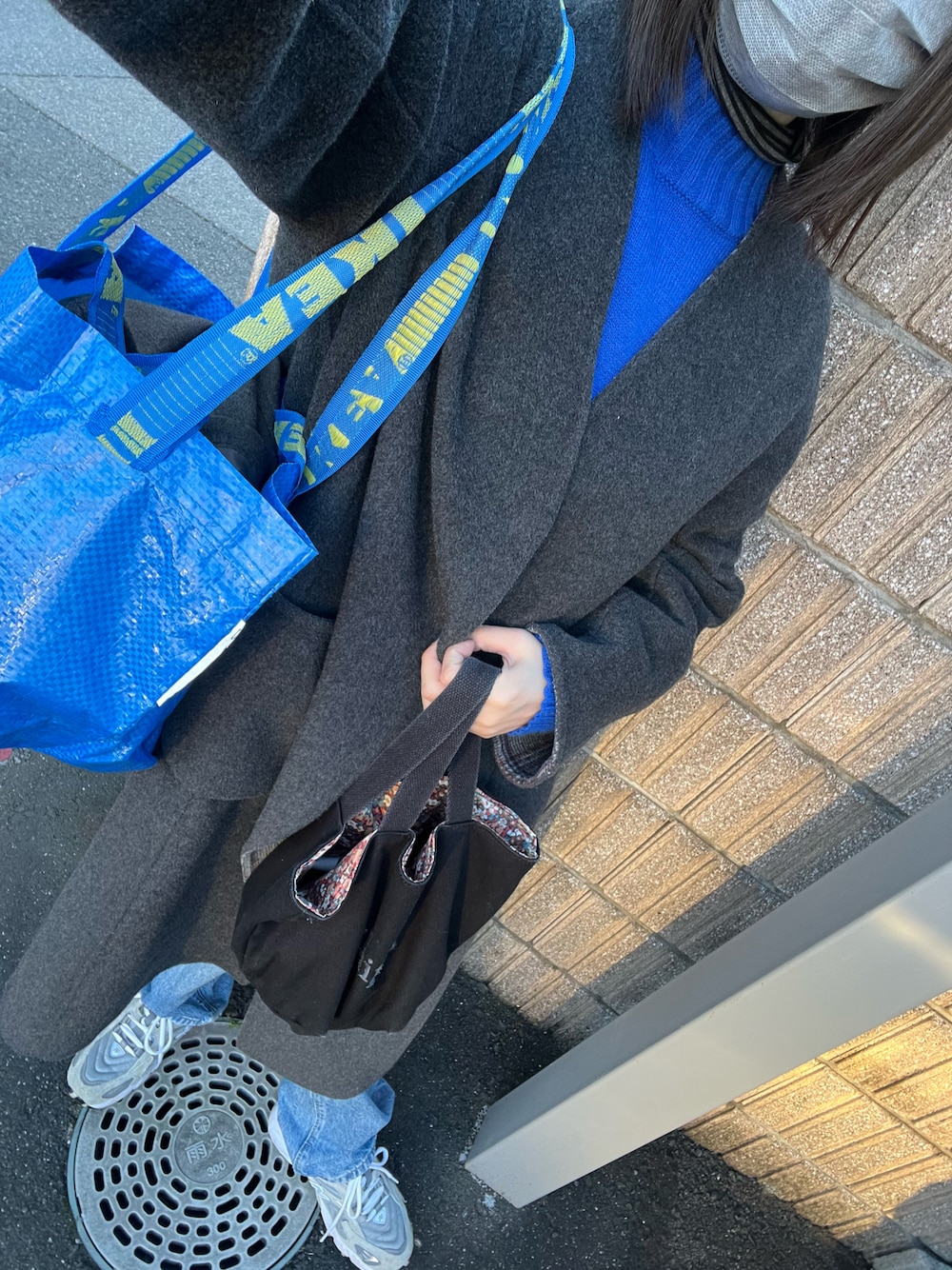 グレー系のその他アウター、ブルー系のデニムパンツ、グレー系のスニーカーを着用したレディースの冬コーディネートの1枚目の写真
