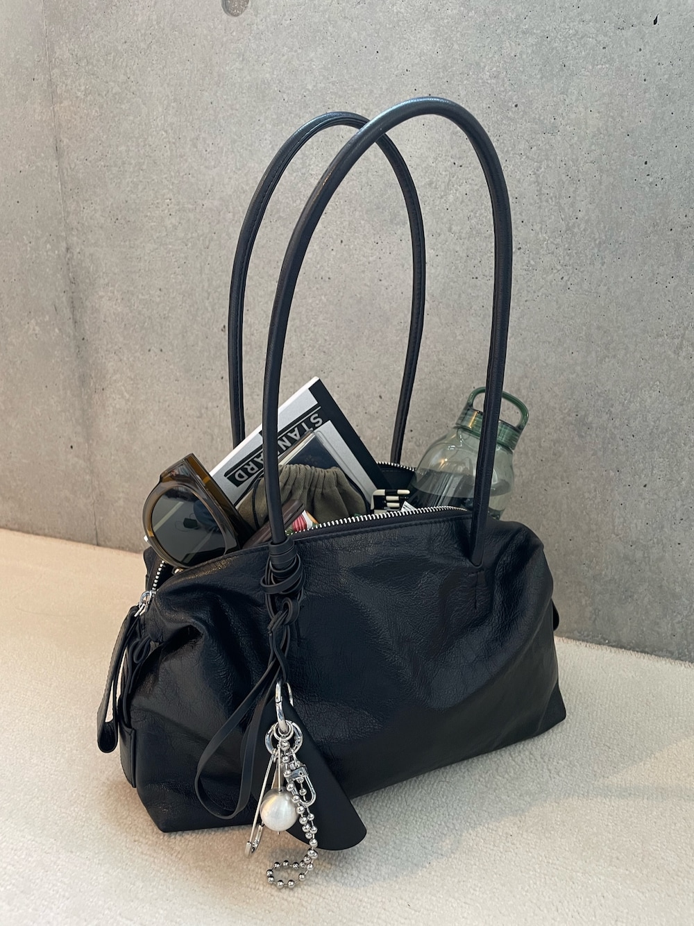 ブラック系のボストンバッグ、ブラック系のチャームを着用したレディースの春コーディネートの1枚目の写真