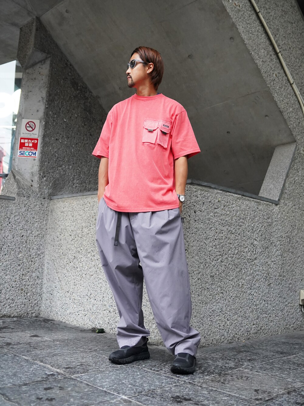 レッド系のTシャツ/カットソー、グレー系のその他パンツ、グレー系のサングラスを着用したメンズの夏コーディネートの1枚目の写真