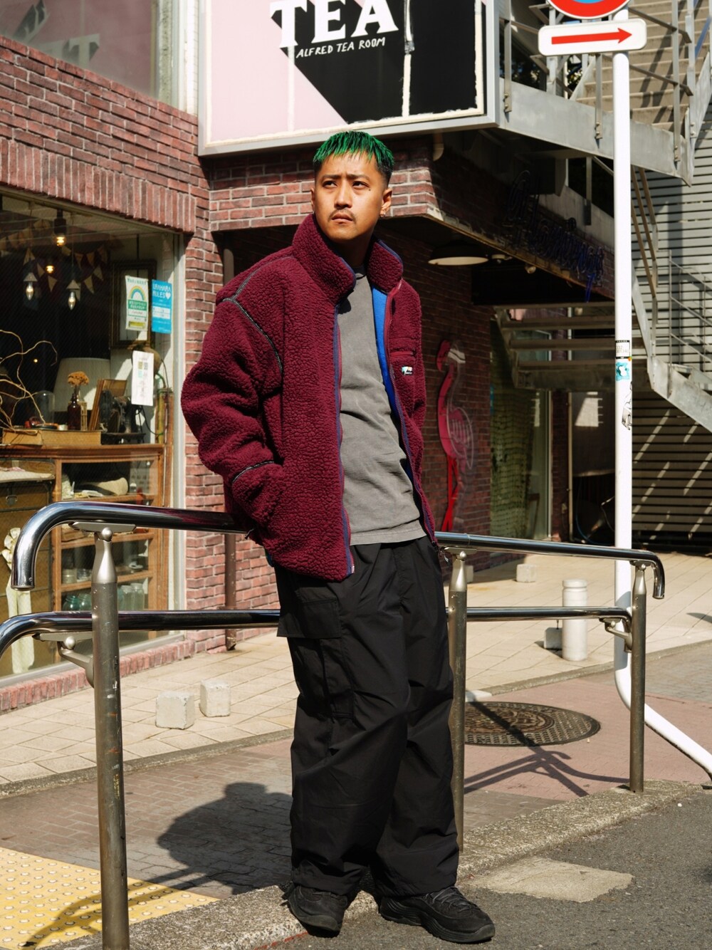 レッド系のブルゾン、グレー系のTシャツ/カットソー、ブラック系のカーゴパンツを着用したメンズの秋コーディネートの1枚目の写真
