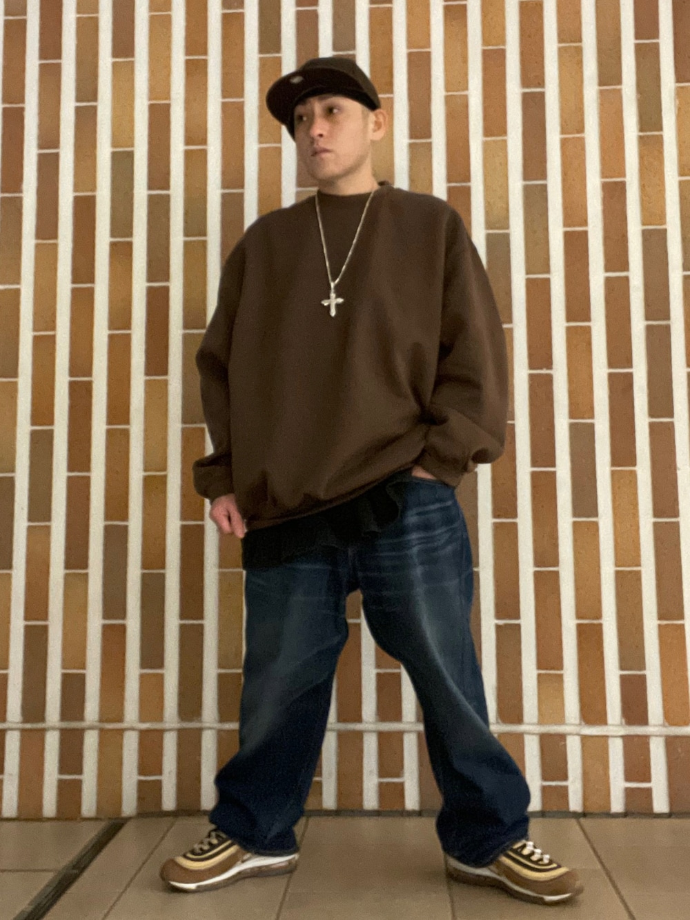 ブラウン系のスウェット、ブラック系のTシャツ/カットソー、ブルー系のデニムパンツを着用したメンズの冬コーディネートの1枚目の写真