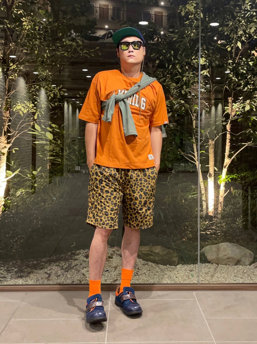 オレンジ系のTシャツ/カットソー、グリーン系のカーディガン/ボレロ、その他のその他パンツを着用したメンズの秋コーディネートの1枚目の写真