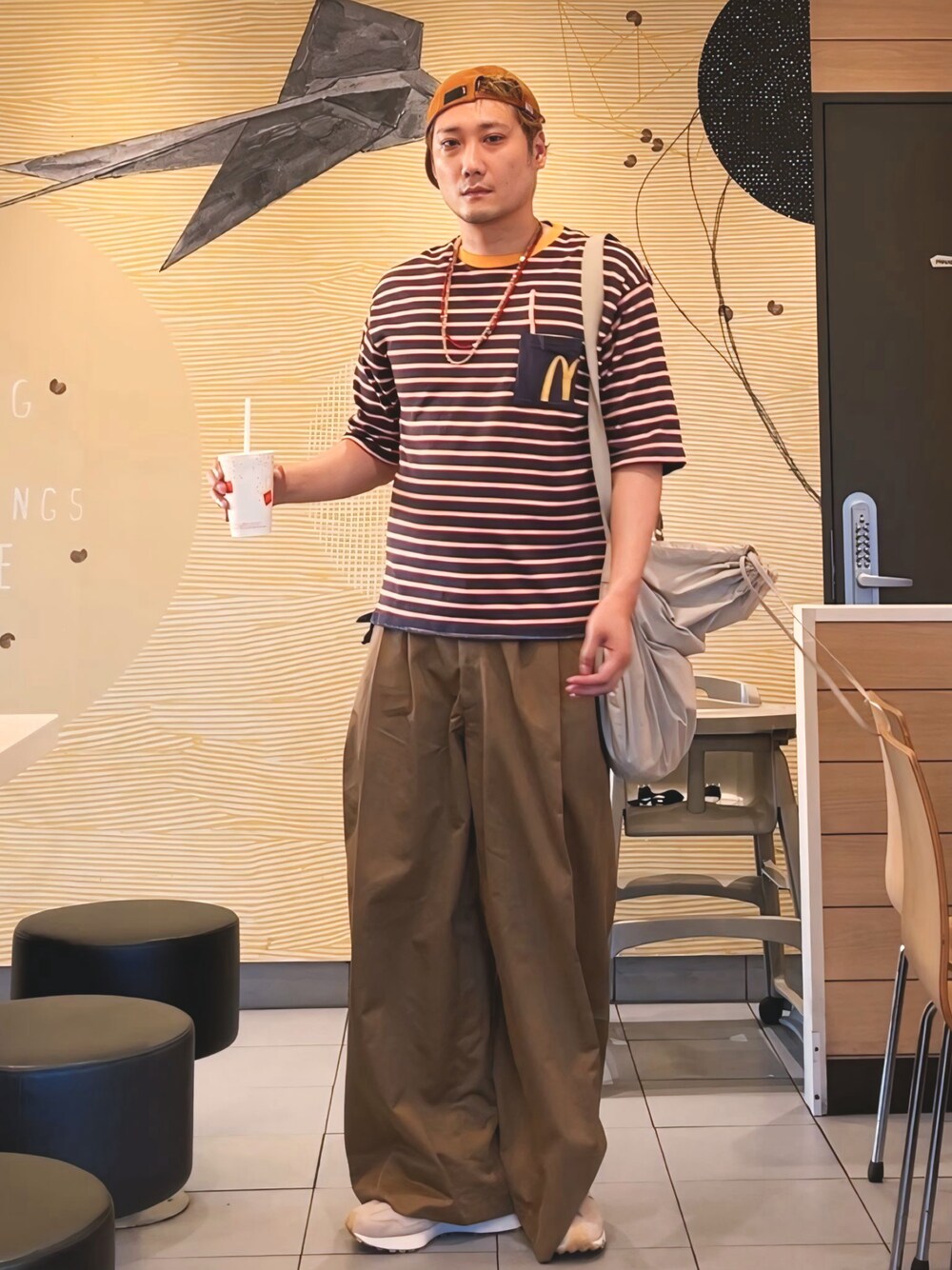 ブルー系のTシャツ/カットソー、ホワイト系のショルダーバッグ、ブラウン系のパンツを着用したメンズの秋コーディネートの1枚目の写真