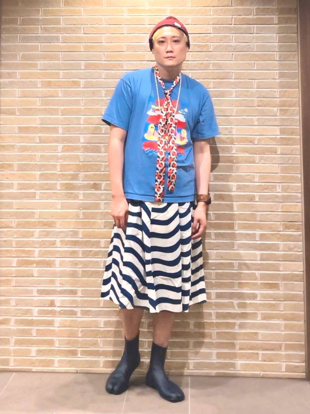 ブルー系のTシャツ/カットソー、ブルー系のスカート、ブラック系のドレスシューズを着用したメンズの夏コーディネートの1枚目の写真