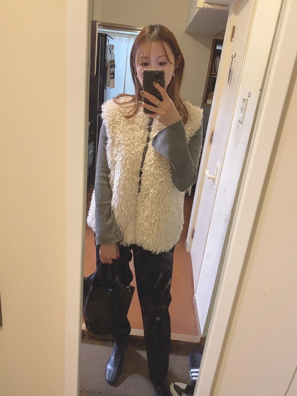 ベージュ系のベスト、グレー系のニット/セーター、ブラック系のハンドバッグを着用したレディースの秋コーディネートの1枚目の写真